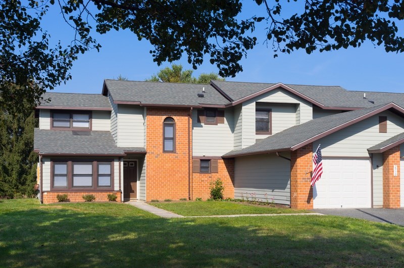 A house with a grey roof and a red brick chimney.