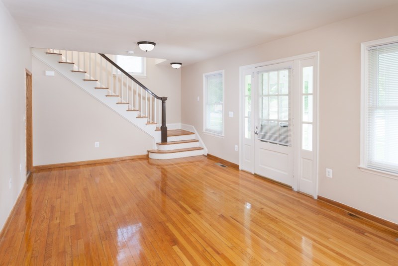 A room with wooden floors and a staircase.