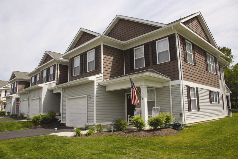 A house with a brown roof and a grey garage door.