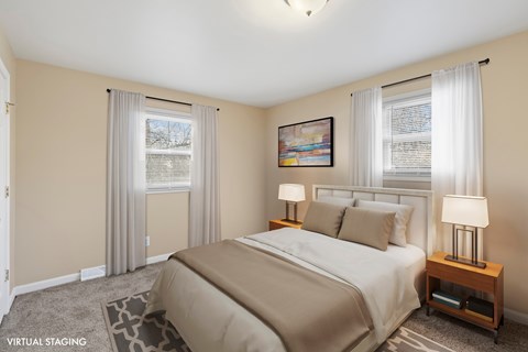 A bedroom with a large bed and a painting on the wall.