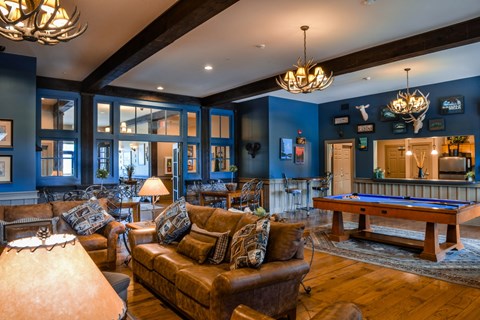 A living room with a pool table and a couch.