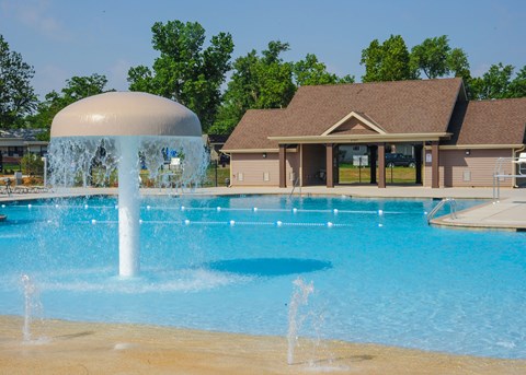 A large pool with a waterfall feature in front of a building.