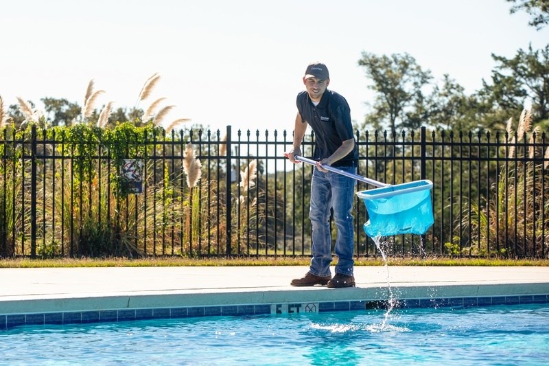 A man is pouring water into a pool.