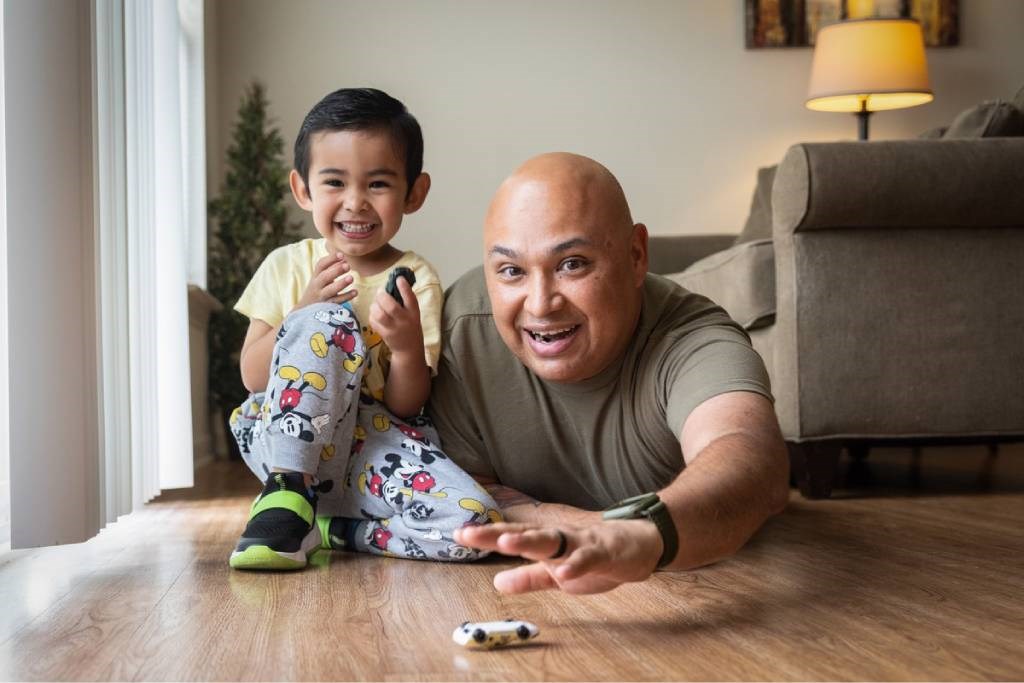 A man and a child on the floor playing with a toy.