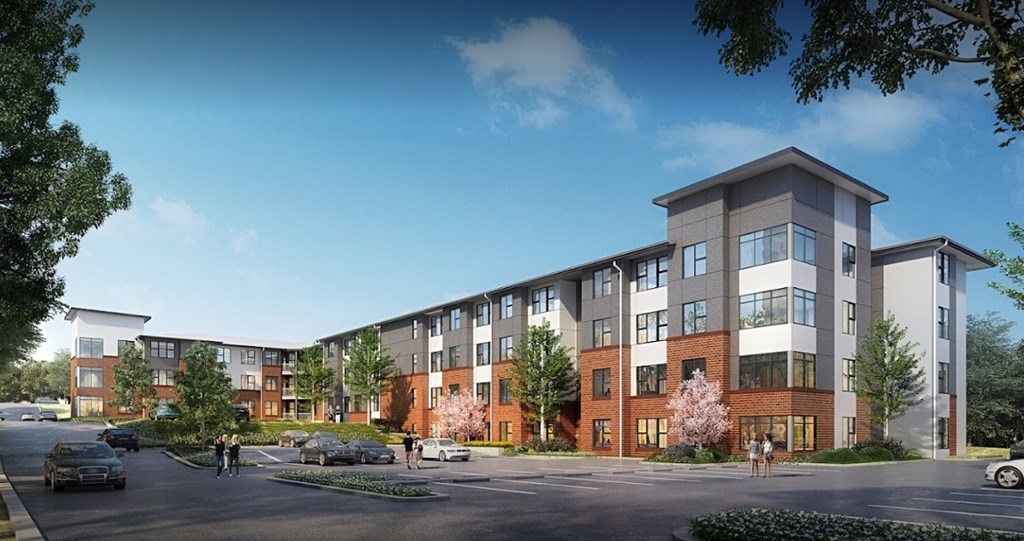 A modern apartment complex with multiple buildings and a parking lot in front.