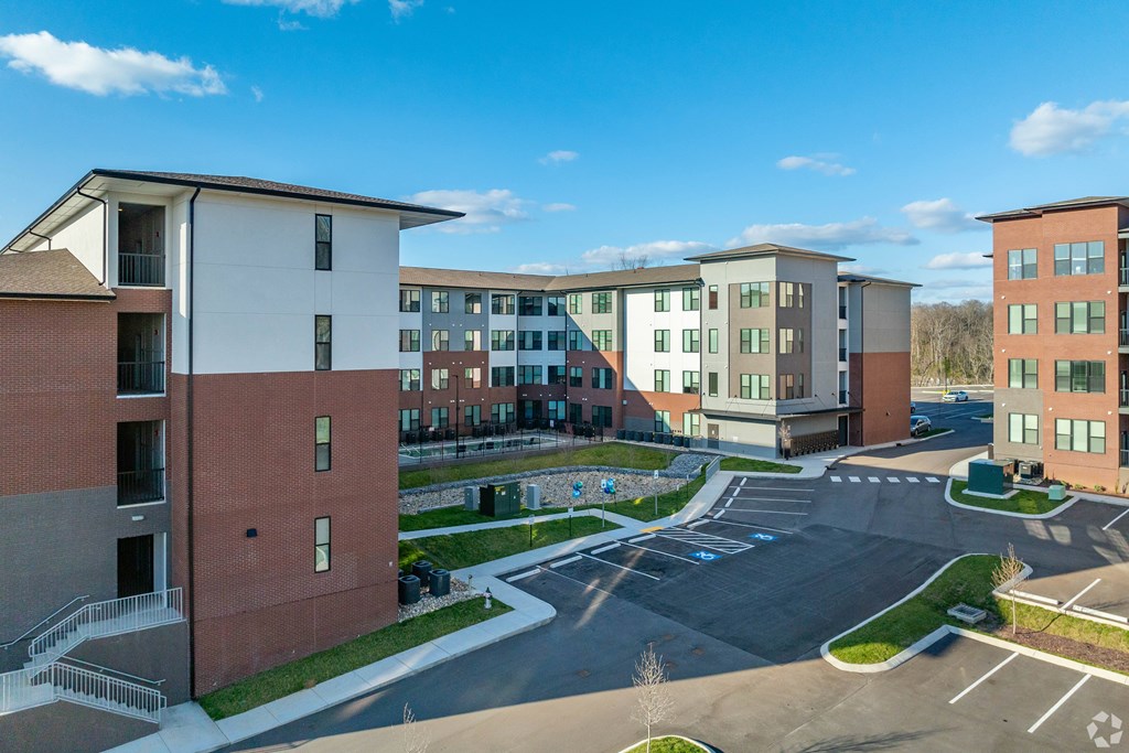 A large building complex with a parking lot in front.