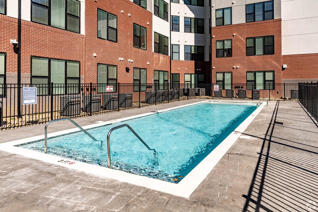 A swimming pool in front of a brick building.
