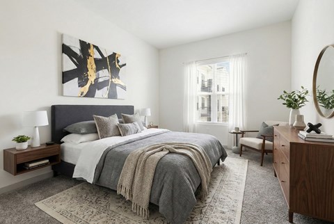 A bedroom with a large bed and a painting on the wall.
