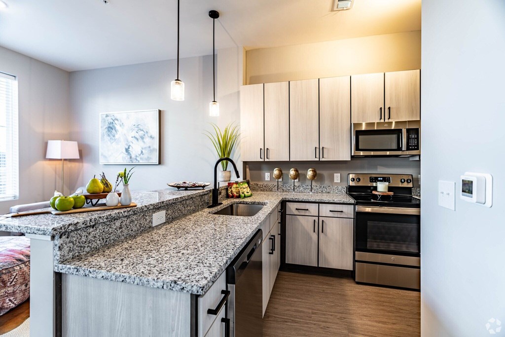 A kitchen with granite countertops and stainless steel appliances.