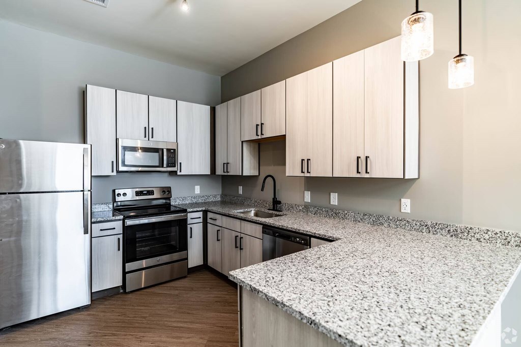 A kitchen with a stove, oven, and microwave.
