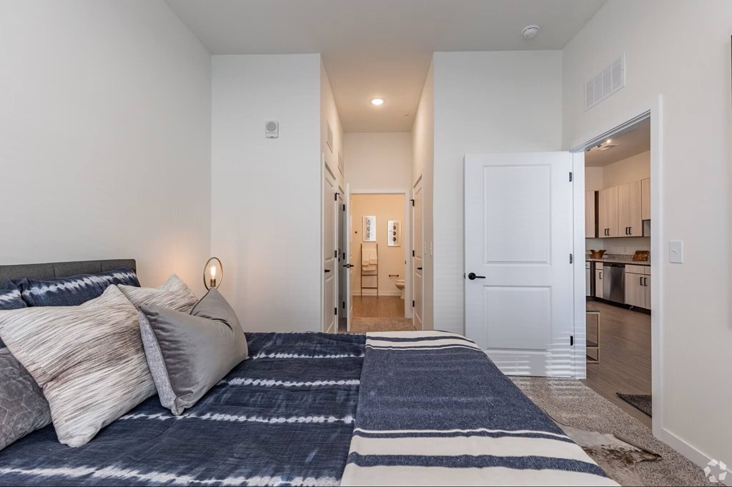 A bedroom with a large bed and a view of the hallway.