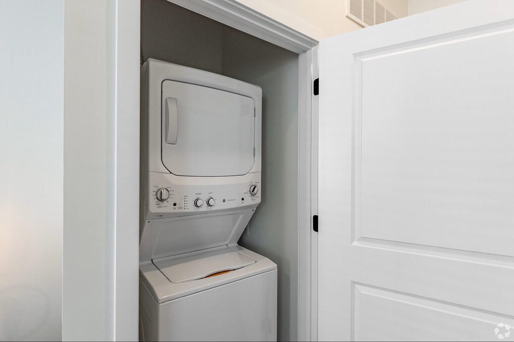 A white dryer is built into a white cabinet.