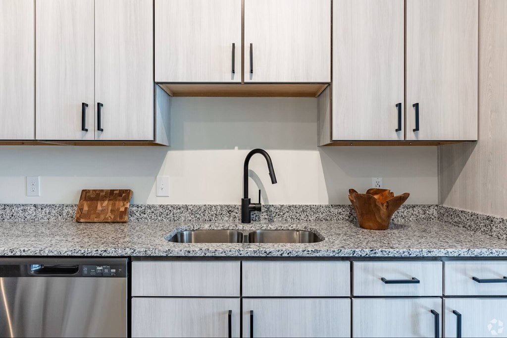 A kitchen with a granite countertop and a sink.