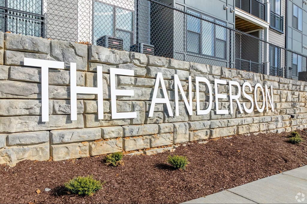 The Anderson sign is made of white letters on a stone wall.