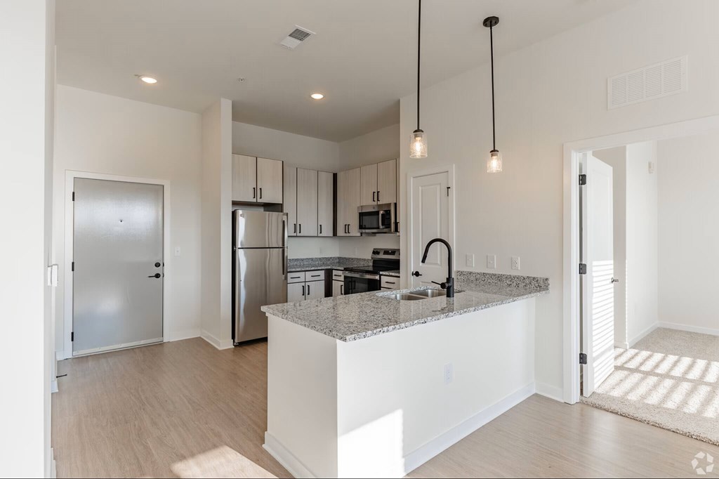 A modern kitchen with a granite countertop and stainless steel appliances.