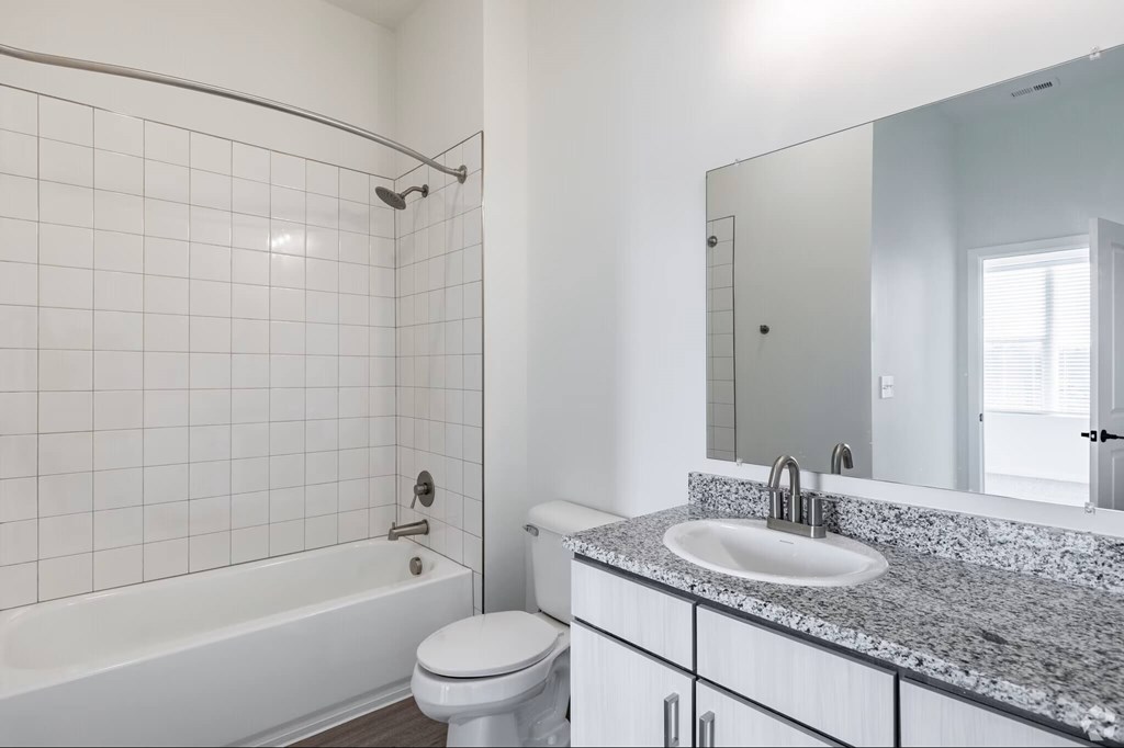 A white bathroom with a sink, toilet, and bathtub.