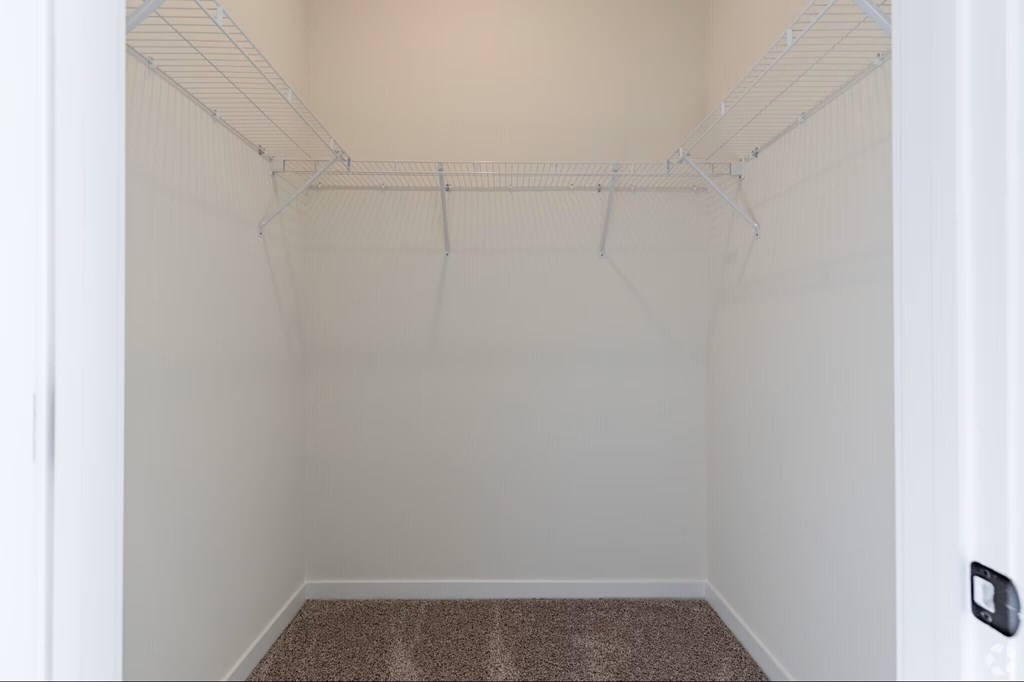 A small, empty room with a carpeted floor and white walls.