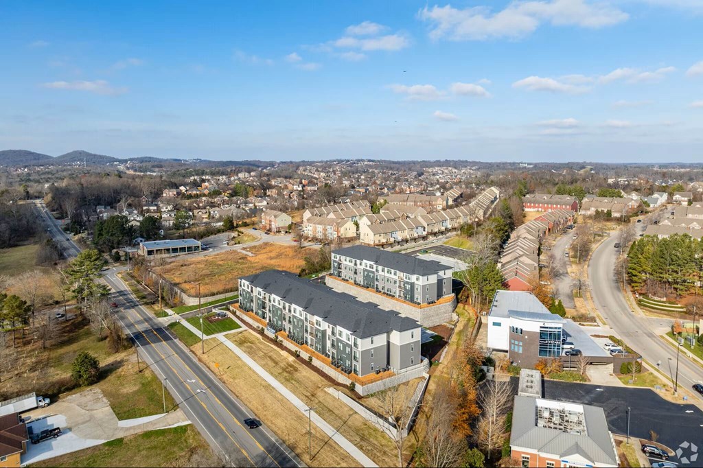 A large building complex is situated in the middle of a road with a clear blue sky above.