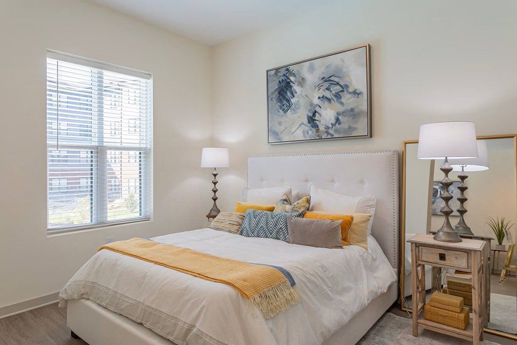 A bedroom with a large bed and a painting on the wall.