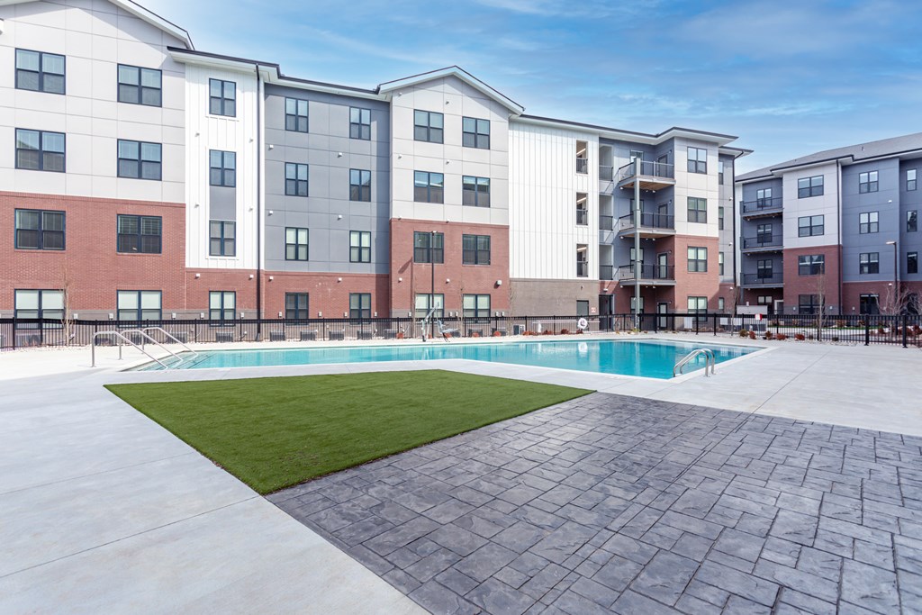 A large apartment complex with a pool in the courtyard.