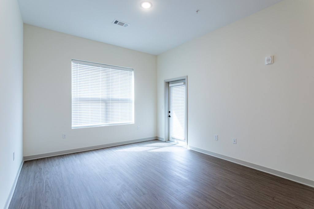 A room with a window and wooden flooring.