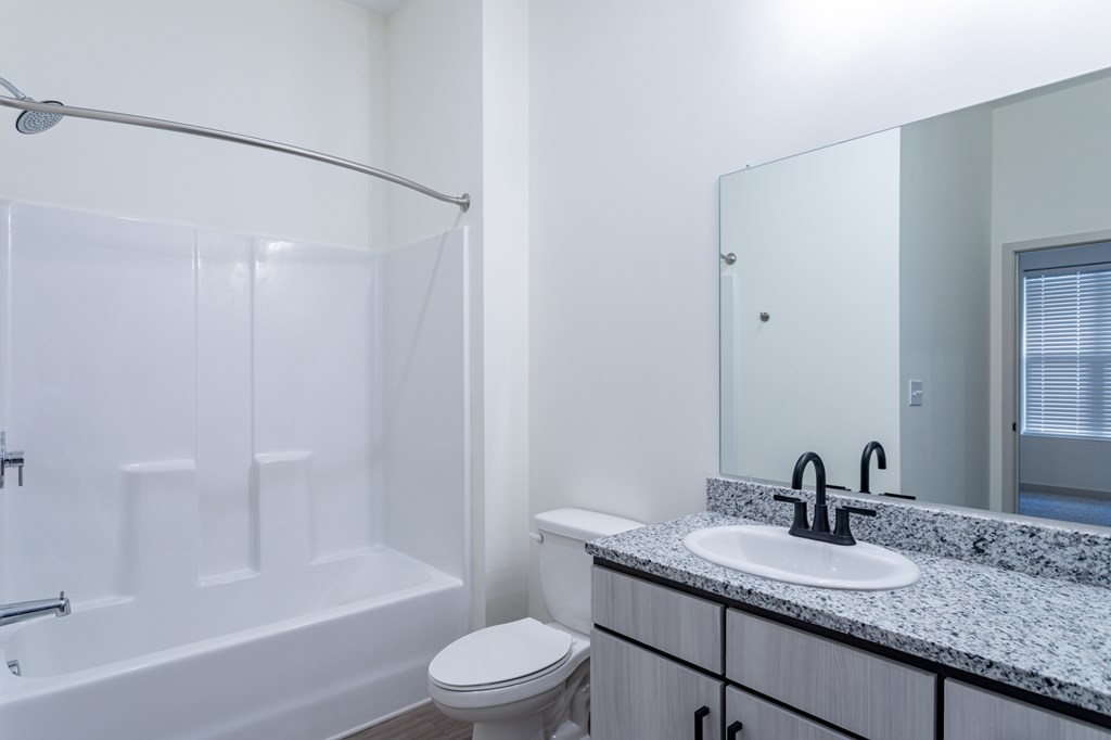 A white bathroom with a toilet, sink, and bathtub.