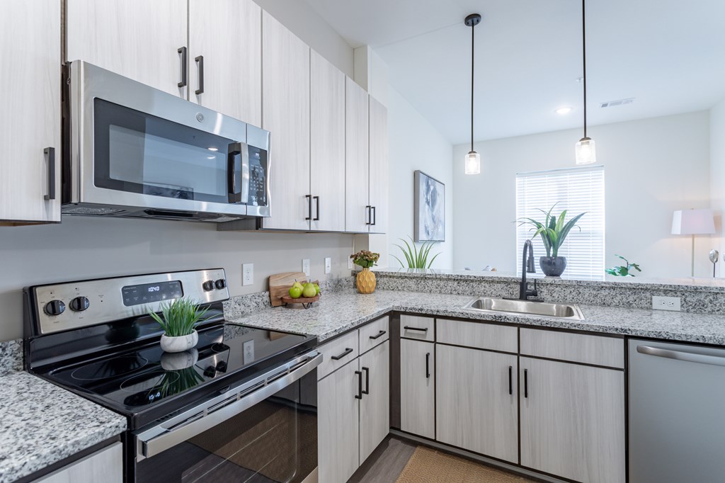 A modern kitchen with a black stove and white cabinets.