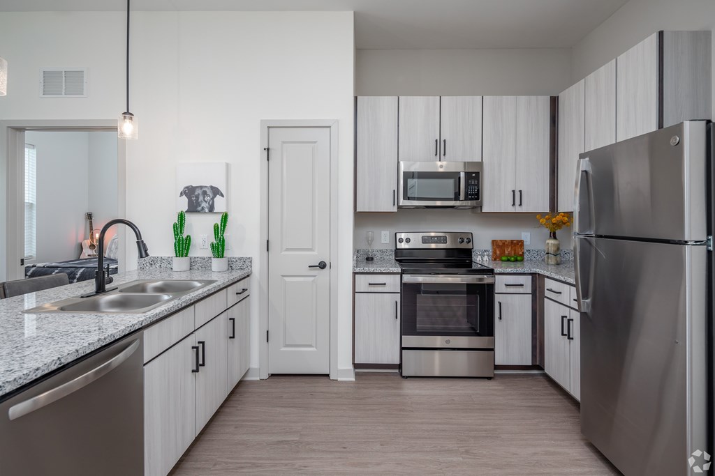 A modern kitchen with stainless steel appliances and white cabinets.
