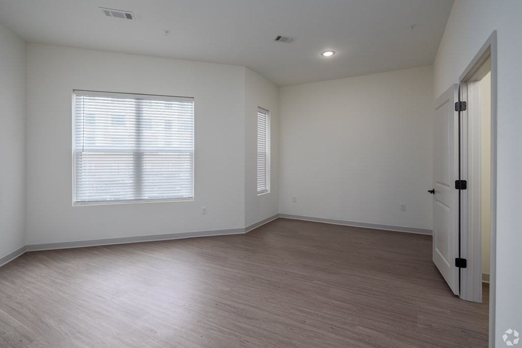 A room with a white door and a window with blinds.