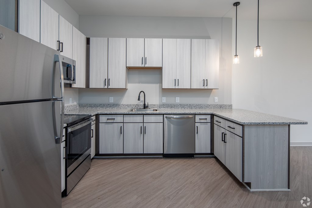 A modern kitchen with stainless steel appliances and wooden cabinets.