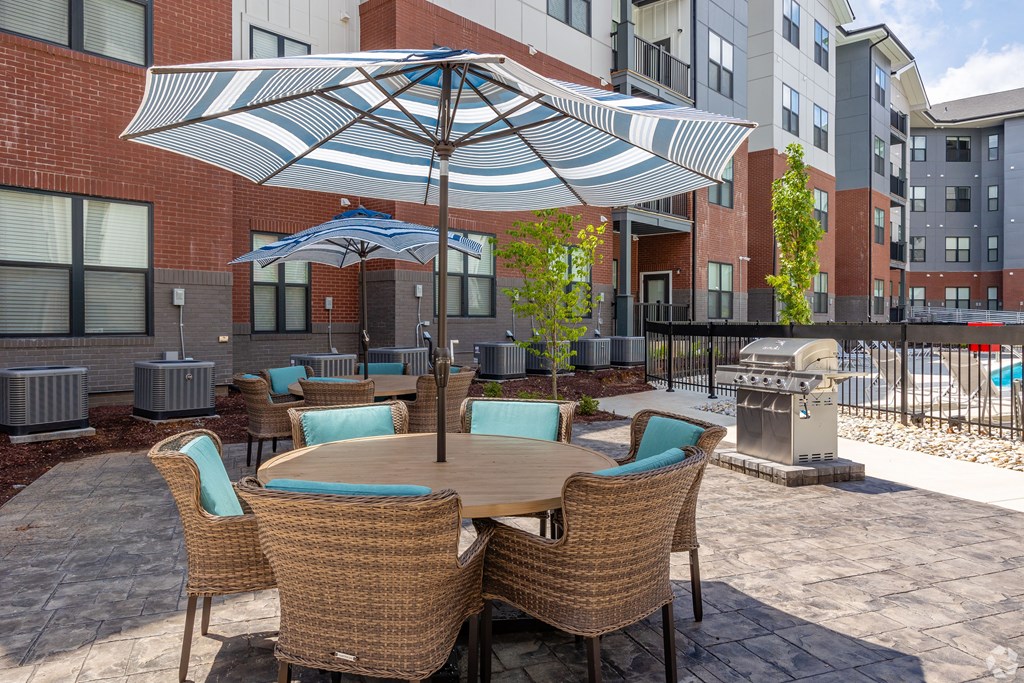 A patio with a table and chairs under an umbrella.