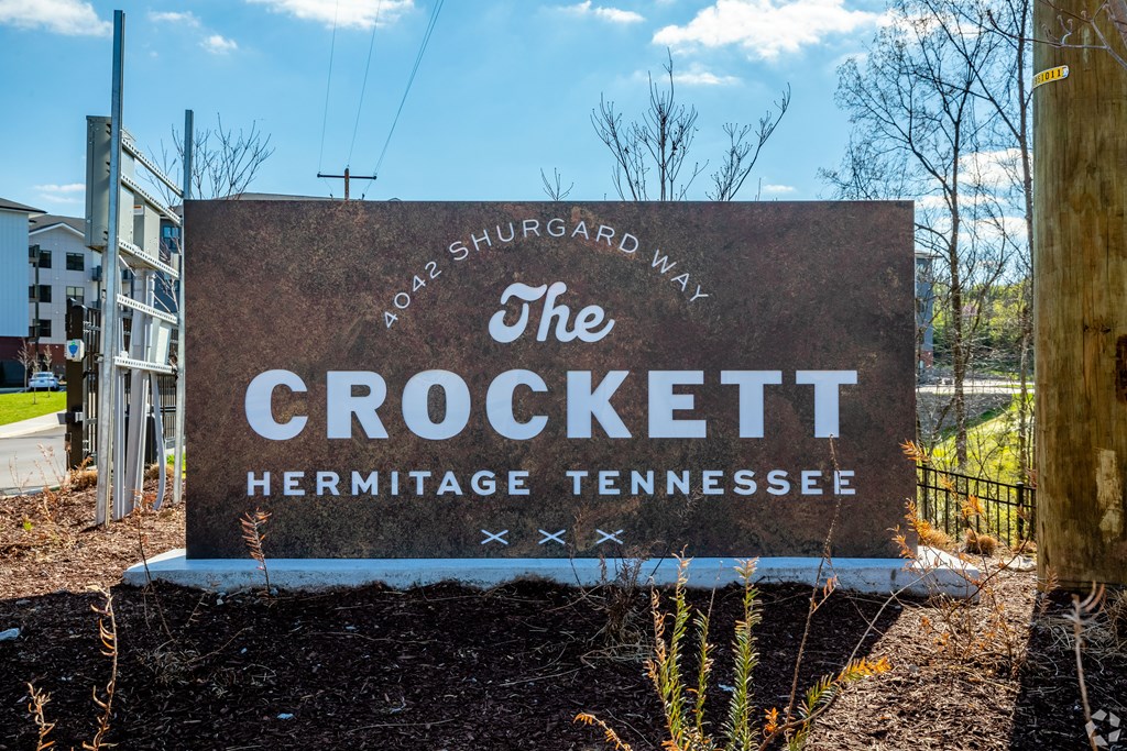 A brown sign with white lettering that says "The Crockett Hermitage Tennessee.".