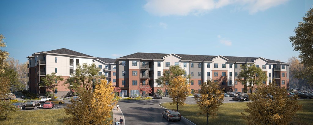 A large apartment complex with a parking lot in front.