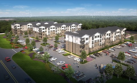 A large apartment complex with a parking lot in front.