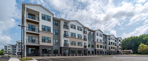 A row of modern apartment buildings with balconies and large windows.
