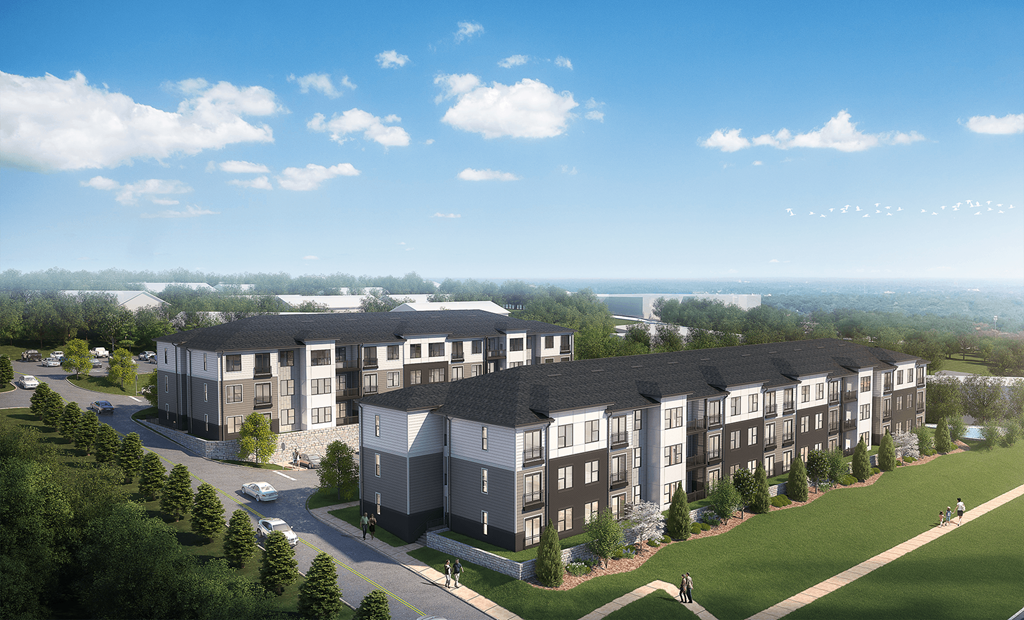 A large apartment complex with multiple buildings and a few cars parked outside.