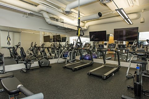 A gym with treadmills, exercise bikes, and other equipment.