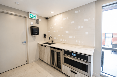 A kitchen with a sink and ovens.