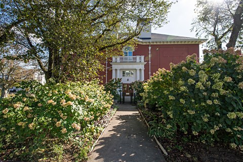 A pathway leads to a building with a balcony.