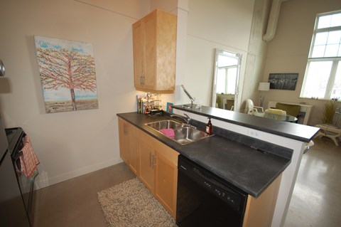 A kitchen with a black counter top and wooden cabinets.