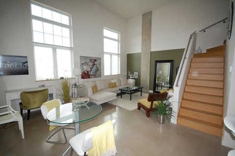 A living room with a glass table and white couches.