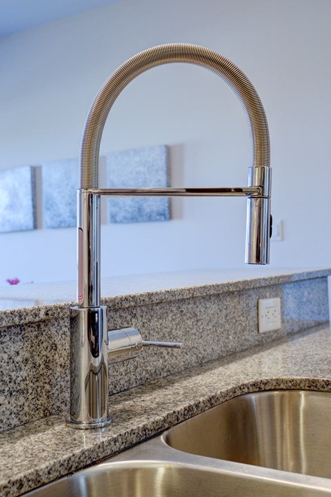 A modern kitchen sink with a chrome faucet.
