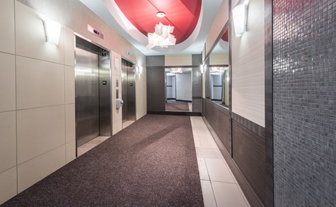 A long hallway with a red ceiling and a carpeted floor.