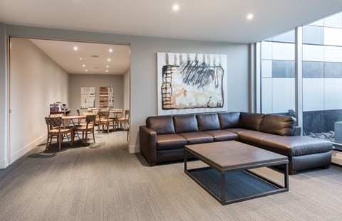 A living room with a brown leather couch and a coffee table.