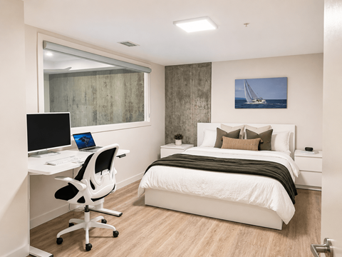 A bedroom with a bed, desk, and chair.