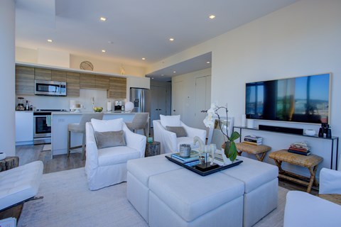 A modern living room with a white sofa set and a television.