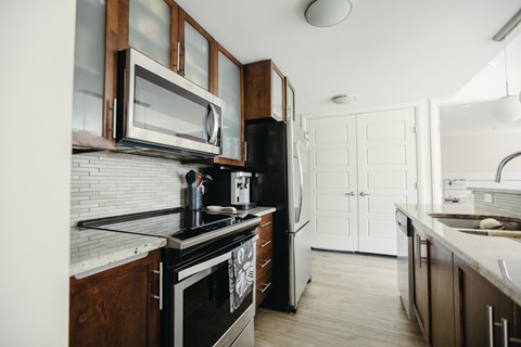 A kitchen with white cabinets and a black stove top oven.
