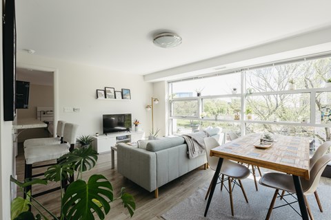 A living room with a couch, a chair, a table and a television.