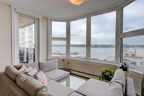 A living room with a couch and a view of the water.