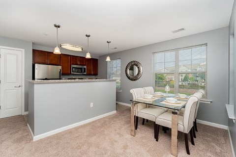 A kitchen with a table and chairs in front of a window.